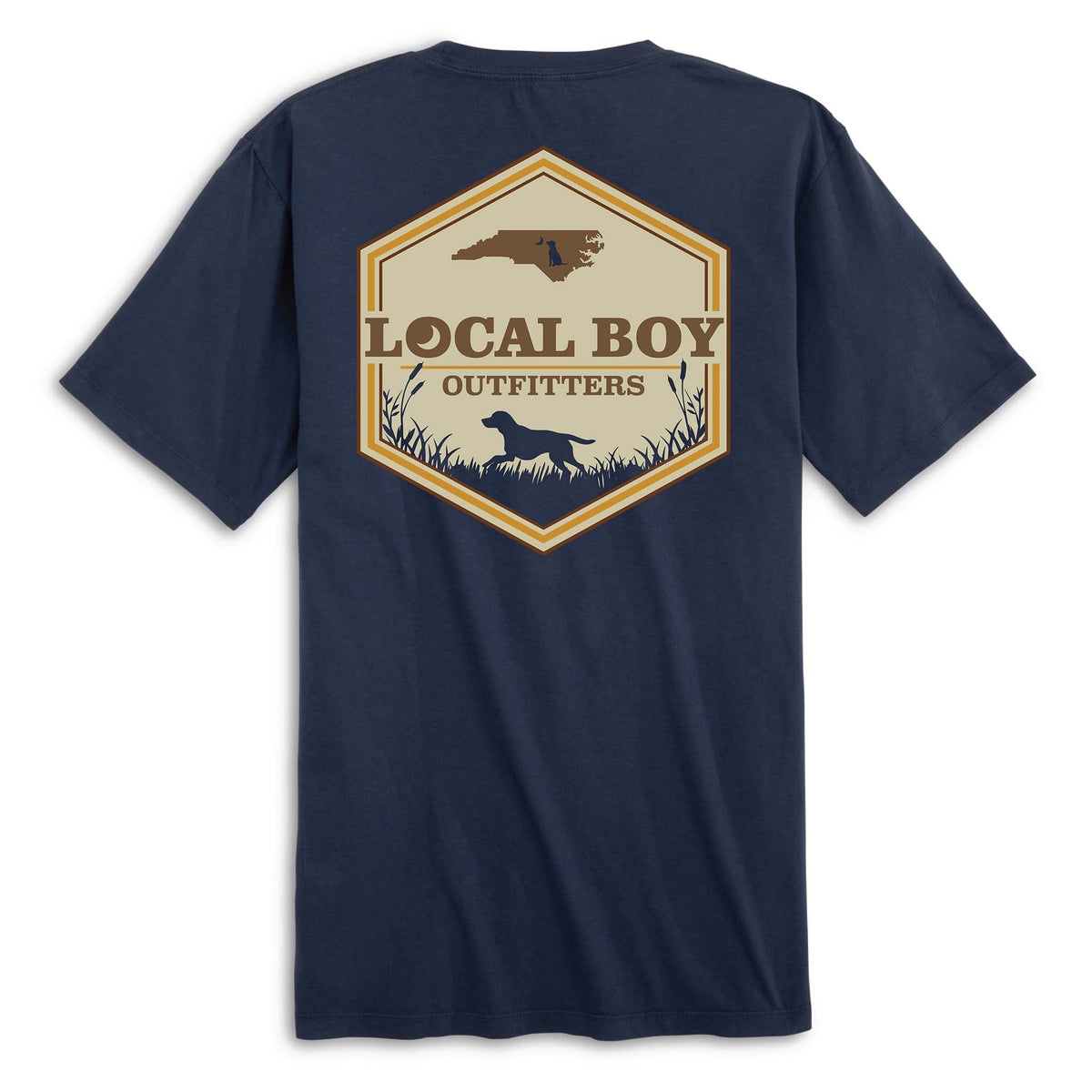 Back view of navy short sleeve t-shirt with large hexagon-shaped graphic featuring a brown silhouette of North Carolina, “Local Boy Outfitters” text, and a black silhouette of a dog standing in grass with cattails.