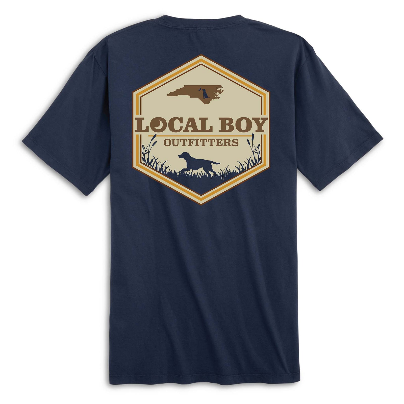 Back view of navy short sleeve t-shirt with large hexagon-shaped graphic featuring a brown silhouette of North Carolina, “Local Boy Outfitters” text, and a black silhouette of a dog standing in grass with cattails.