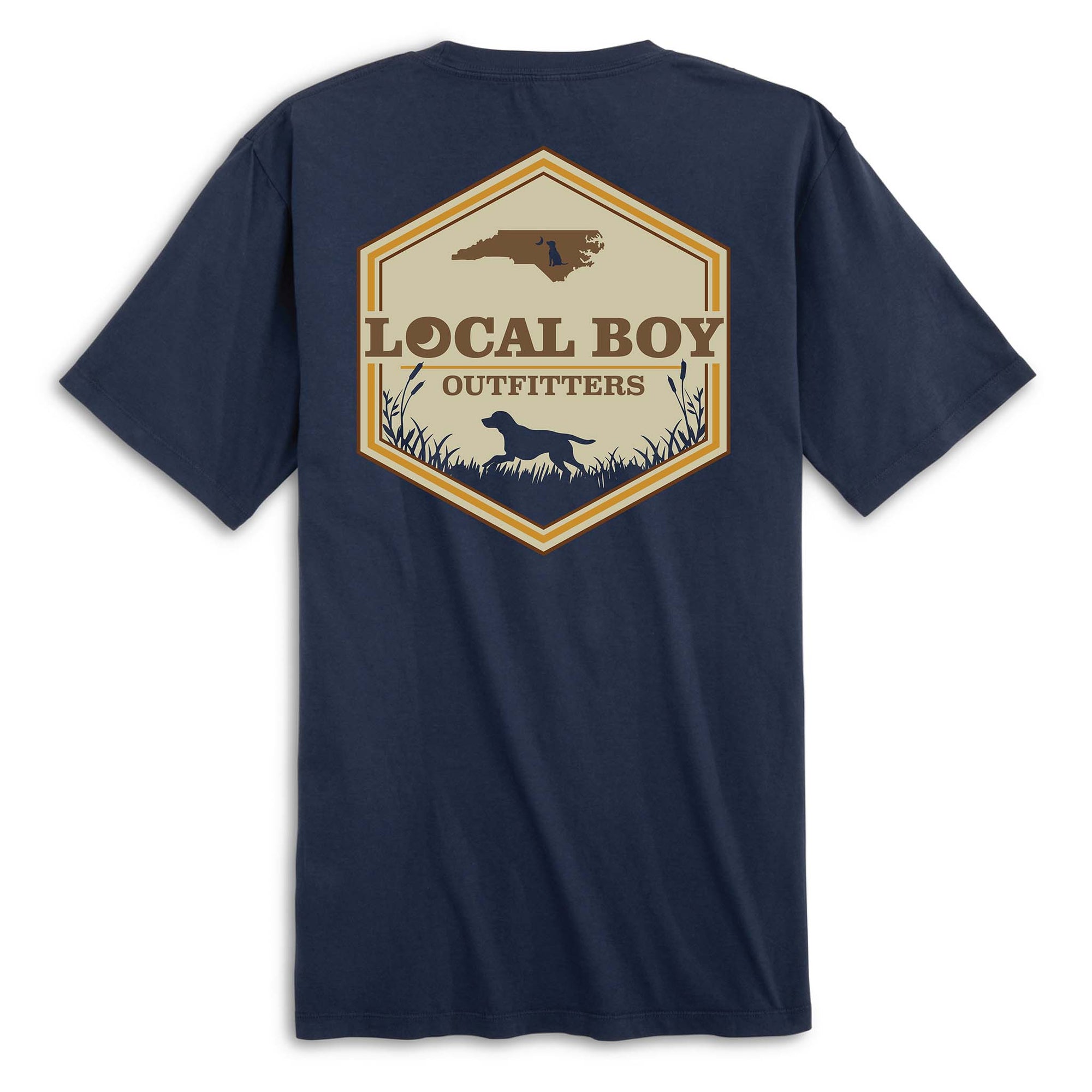 Back view of navy short sleeve t-shirt with large hexagon-shaped graphic featuring a brown silhouette of North Carolina, “Local Boy Outfitters” text, and a black silhouette of a dog standing in grass with cattails.