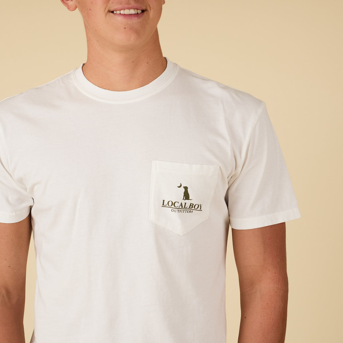 Front view of white Local Boy Outfitters pocket t-shirt with small logo featuring dog and crescent moon on the chest pocket.