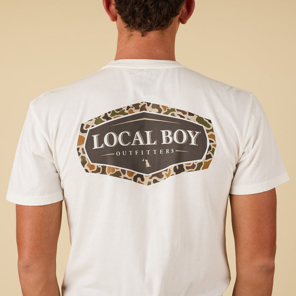 Close-up back view of white Local Boy Outfitters t-shirt with camo-outlined logo graphic.