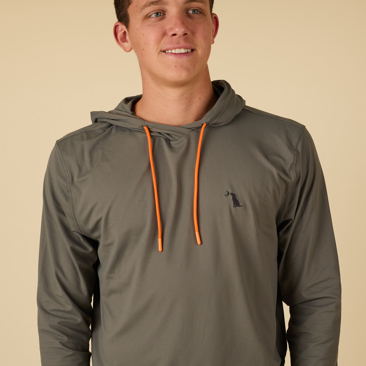 Man wearing a green performance hoodie with orange drawstrings.