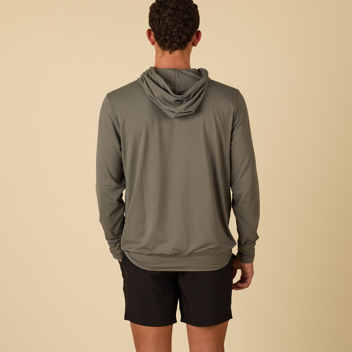 Back of man wearing a green performance hoodie.