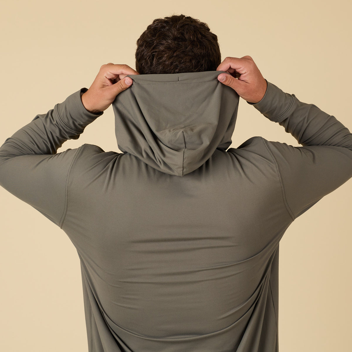 Man pulling up the hood on a performance hoodie.