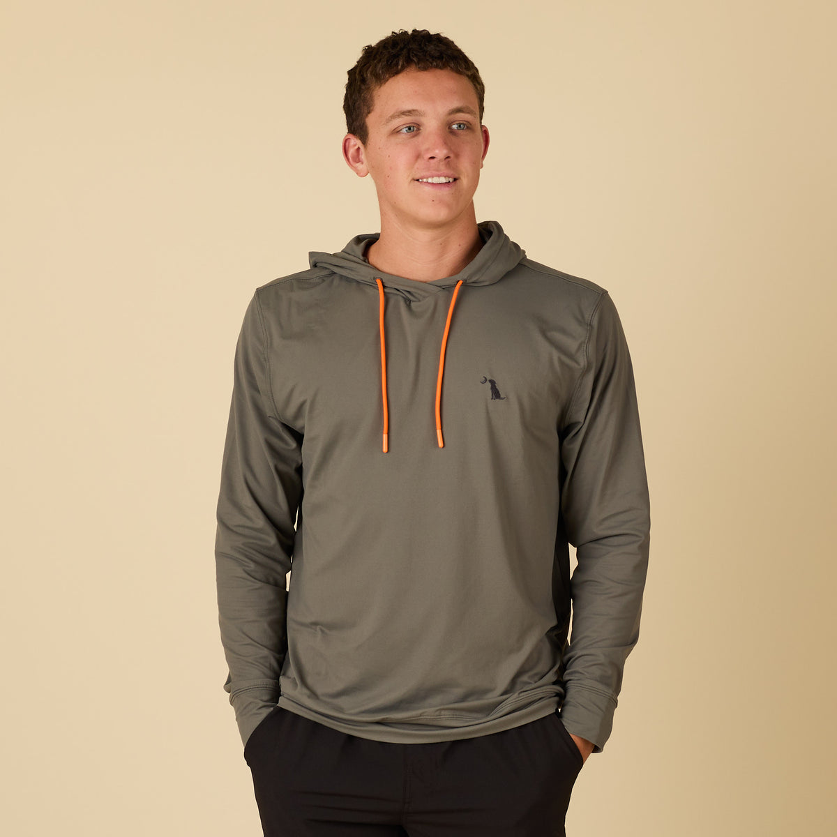 Man wearing a green performance hoodie and black shorts.