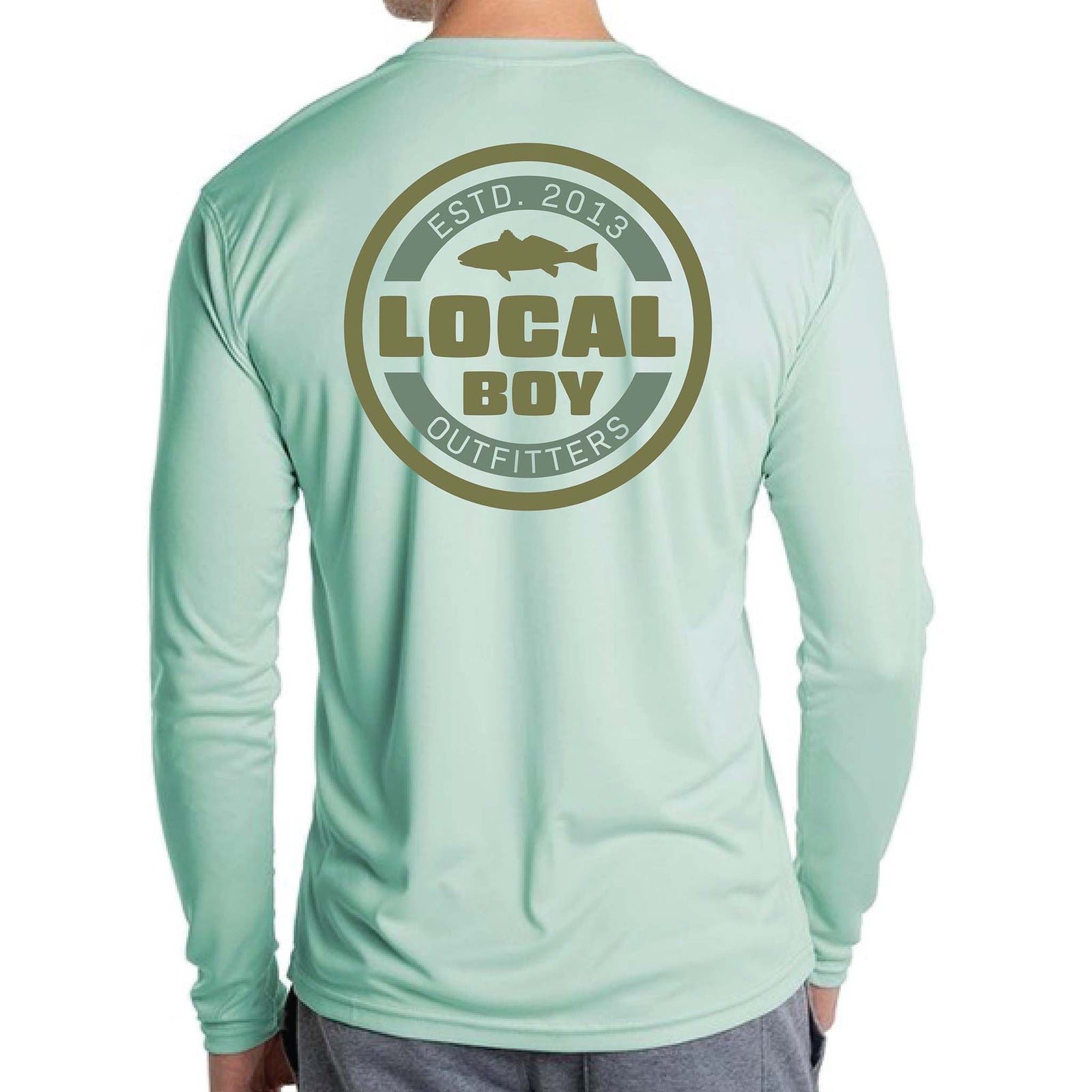 Back view of seagrass green Local Boy Outfitters long sleeve shirt with large circular logo reading “Local Boy Outfitters ESTD. 2013” and a fish silhouette in the center.
