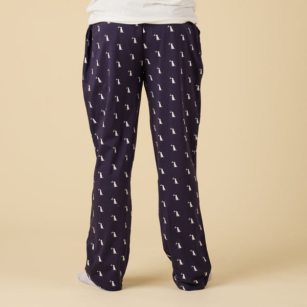 Navy blue pajama pants with white dog pattern on a beige background