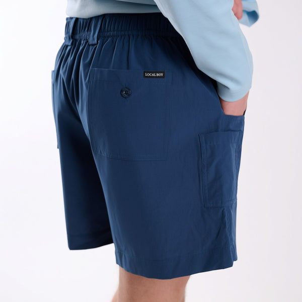 Back angled view of navy fishing shorts.