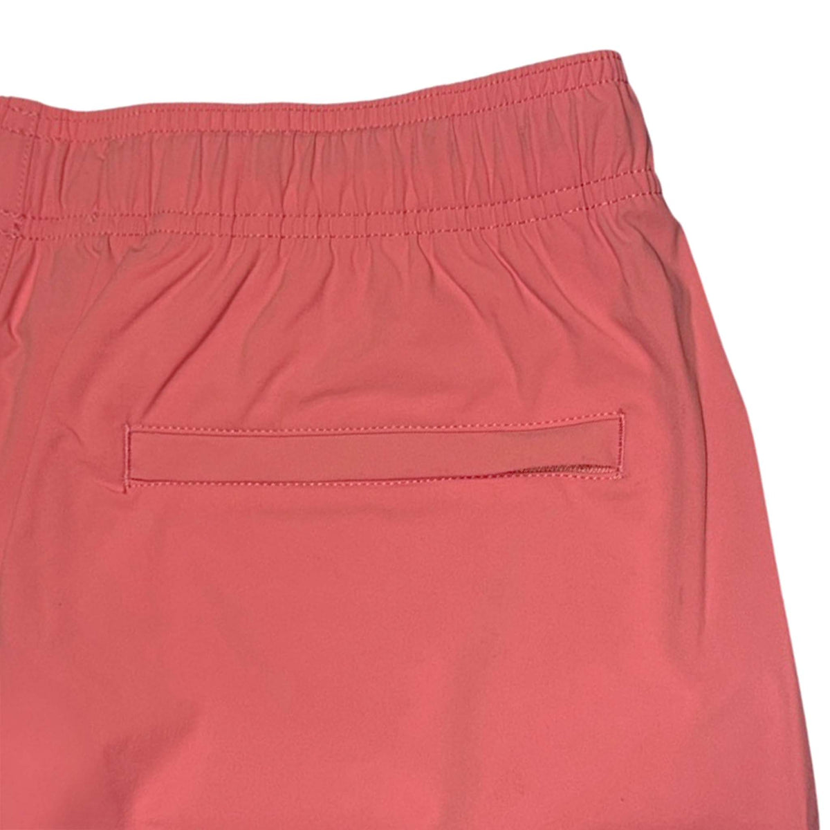 close up back view of Local Boy Outfitters Men's Bayview swim shorts in bright coral showing one back pocket 