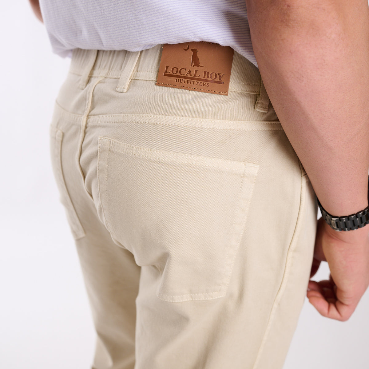 Beige pants with a visible brand label on a white background