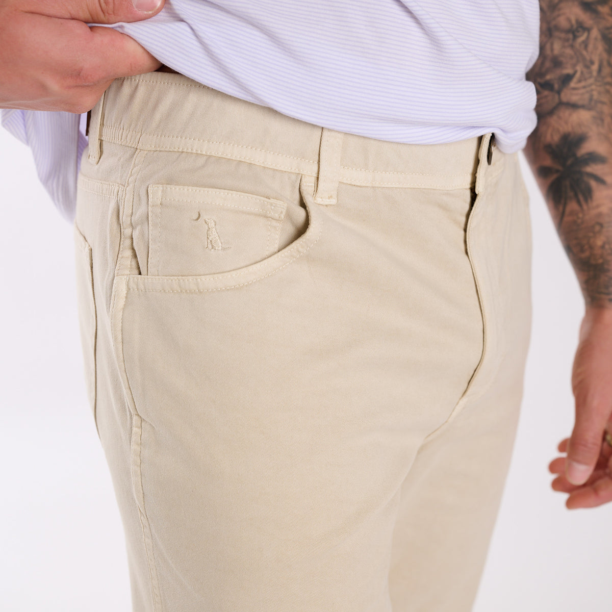 Beige pants with a brand logo on a white background