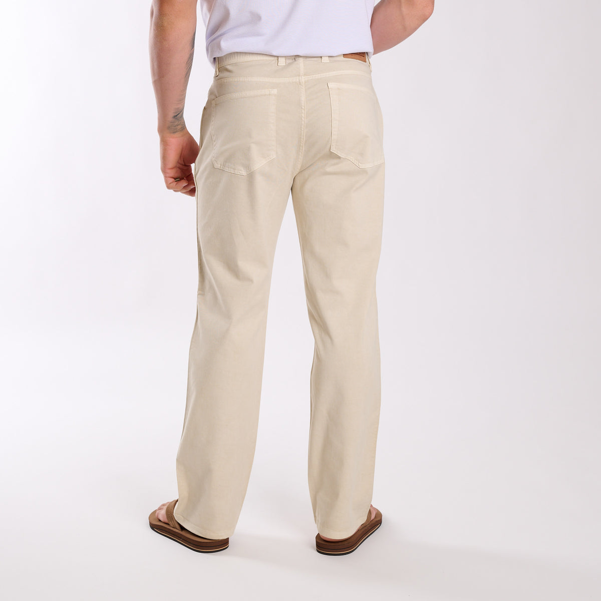 Beige pants worn by a person on a white background