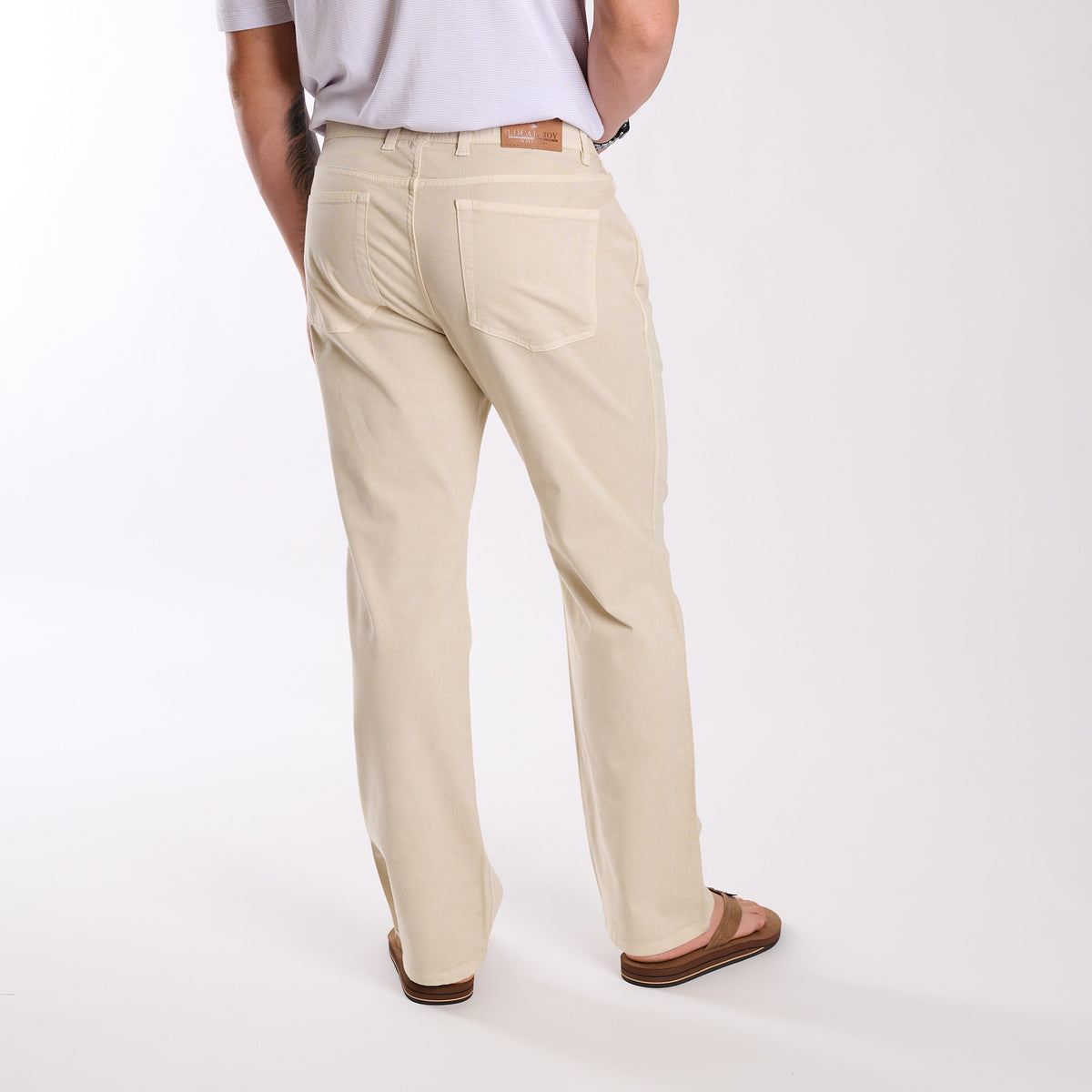 Person wearing beige pants on a white background