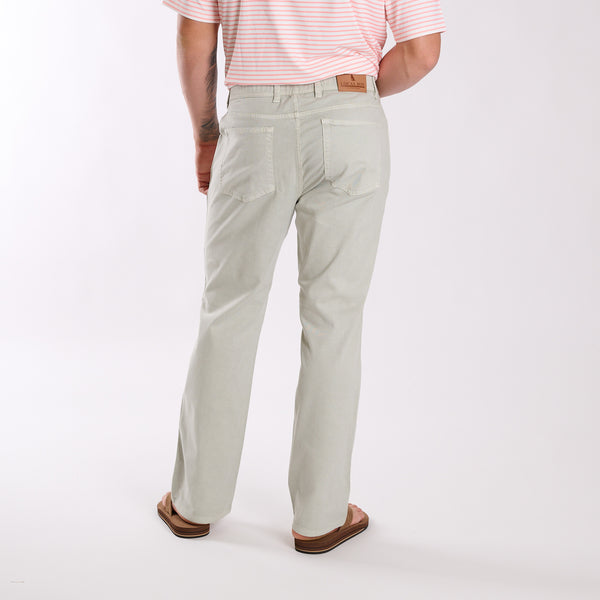 Person wearing light gray pants and a pink striped shirt on a white background