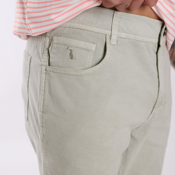 Person wearing light gray pants with a brand logo on a white background