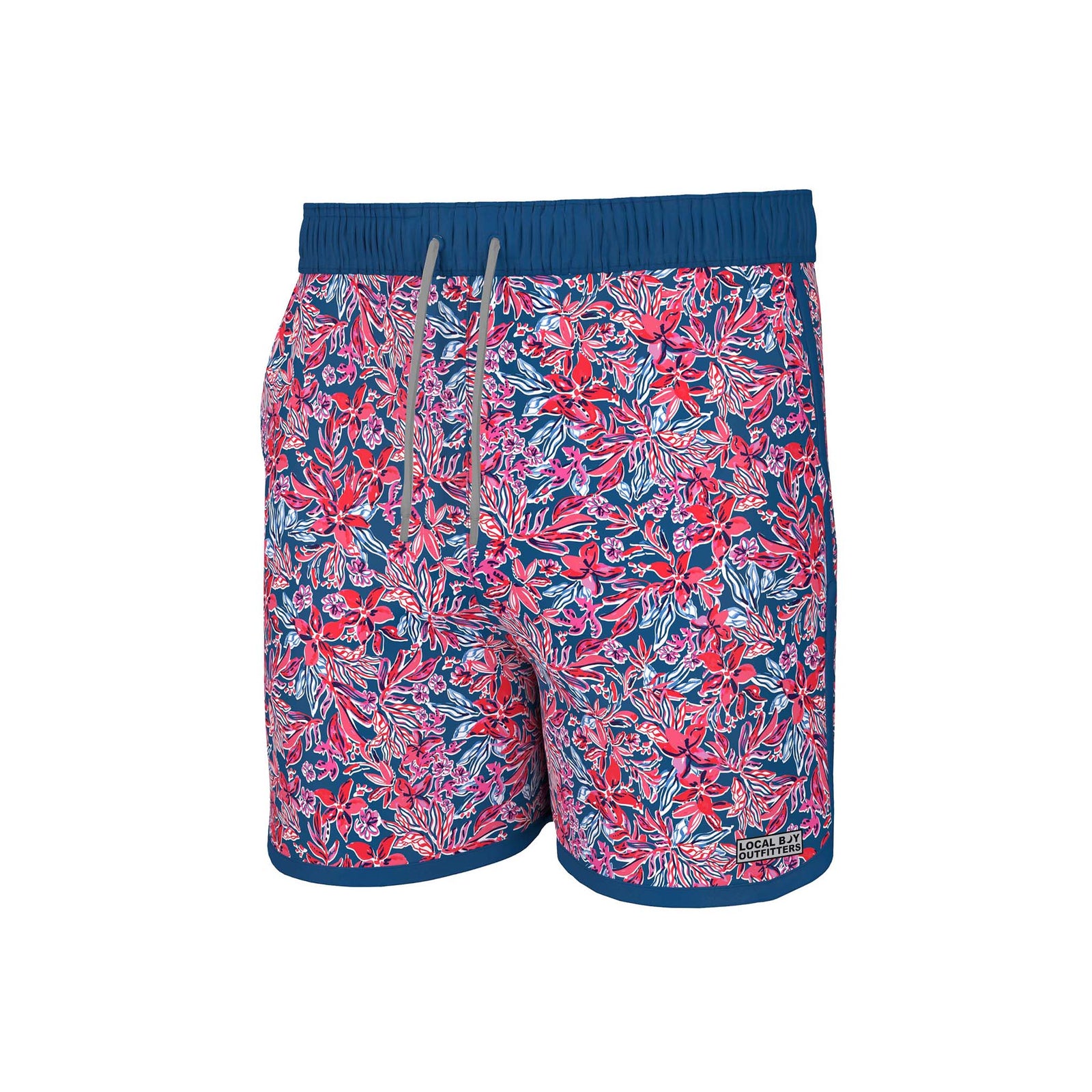 Local Boy Outfitters Youth Wando Swim Trunks in Tropical USA, sizes youth XS-XL, 95% nylon, 5% elastane, elastic drawstring waistband.
Youth swim trunks featuring a vibrant red, pink, and white tropical floral pattern on a navy blue background. The shorts have a blue waistband with a gray drawstring and matching blue trim along the hem. A "Local Boy Outfitters" logo patch is located near the lower leg.