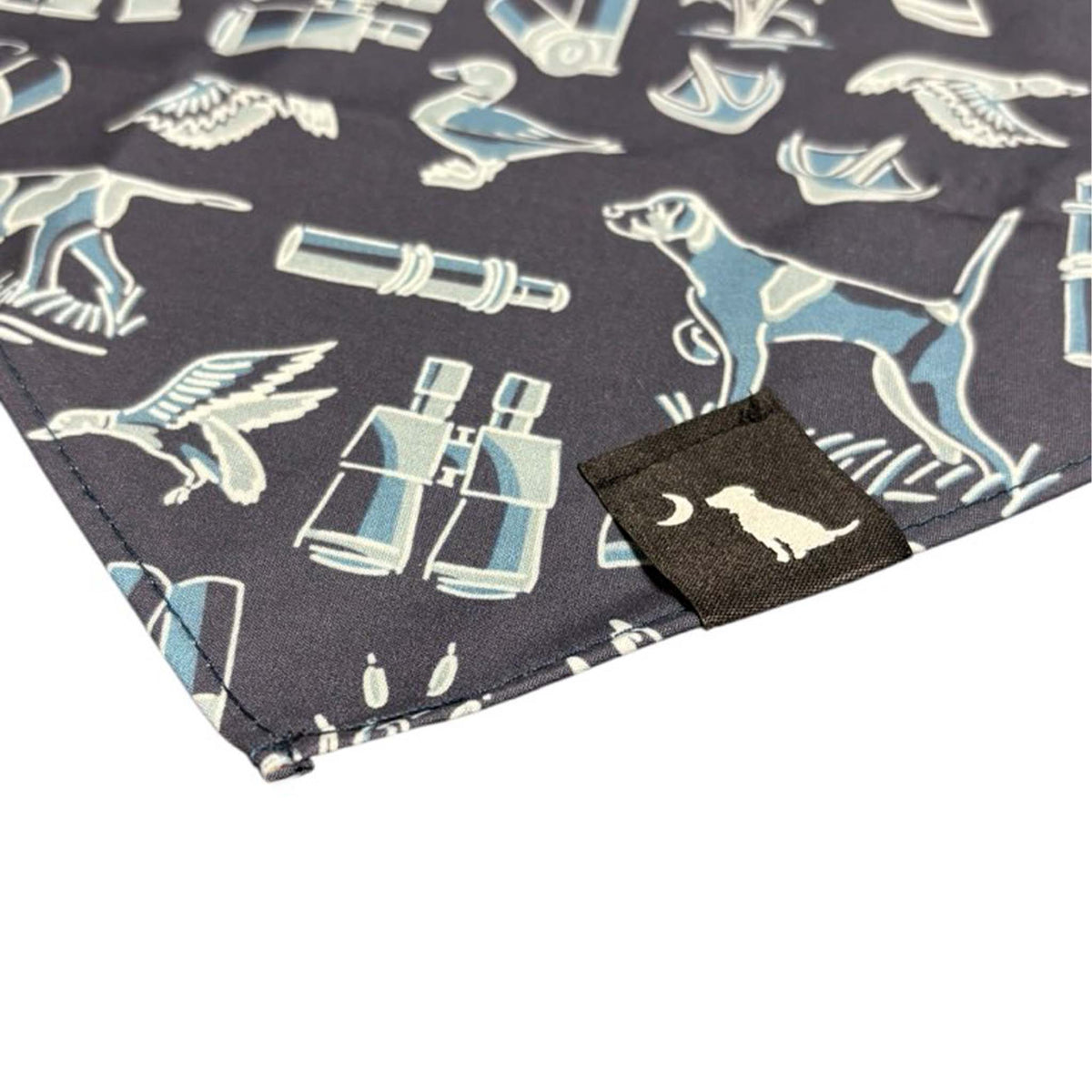 Close-up of the navy bandana showing embroidered Local Boy tag and detailed illustrations of a hunting dog, binoculars, and flying birds.