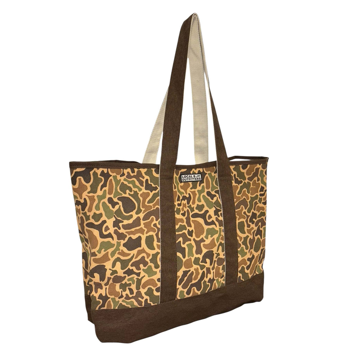 Angled side view of Local Boy Outfitters tote bag with camouflage pattern and long brown straps.