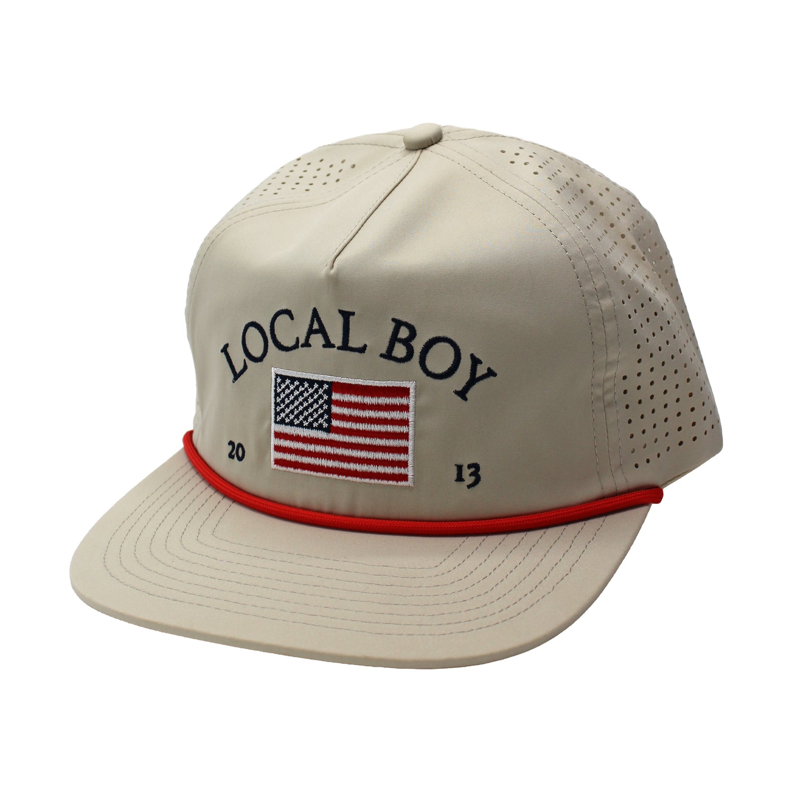 Tan Local Boy Outfitters perforated hat with American flag and brand name embroidered on crown.  Shown on a white background.