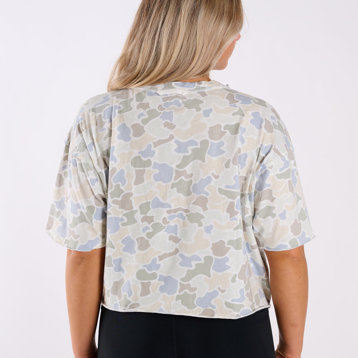Back view of woman wearing a white camo athletic top.