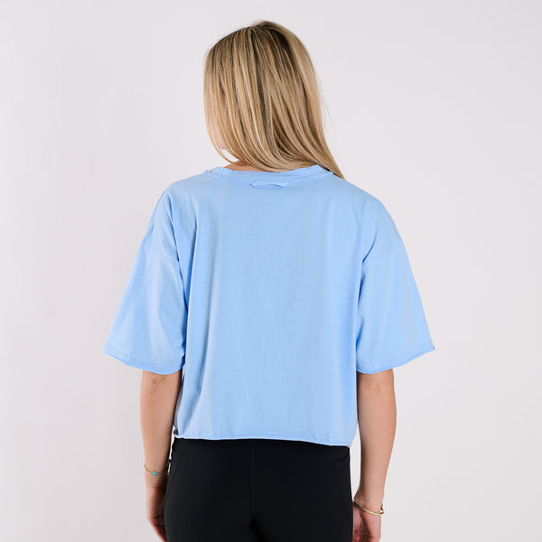 Person wearing a light blue t-shirt on a plain background
