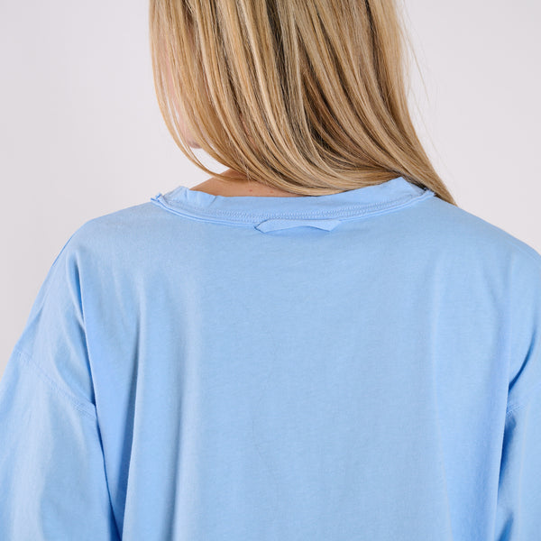 Light blue athletic shirt worn by a person with a plain background