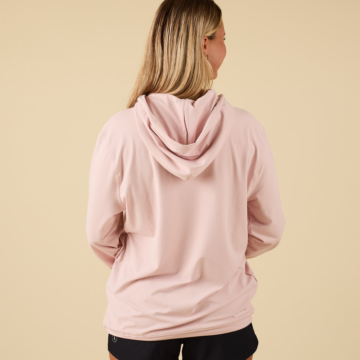 Full back view of Local Boy Outfitters performance hoodie in light pink with hood down.
