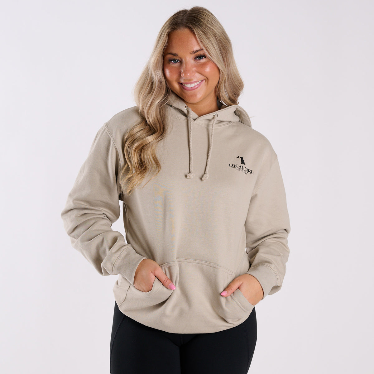 Woman wearing a beige hoodie with a logo on a white background