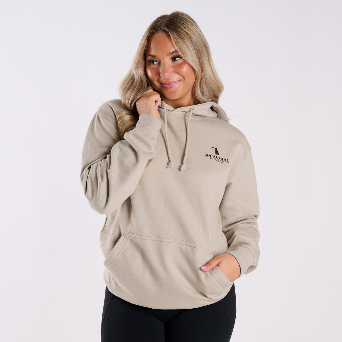 Woman wearing a beige hoodie with a logo on a white background