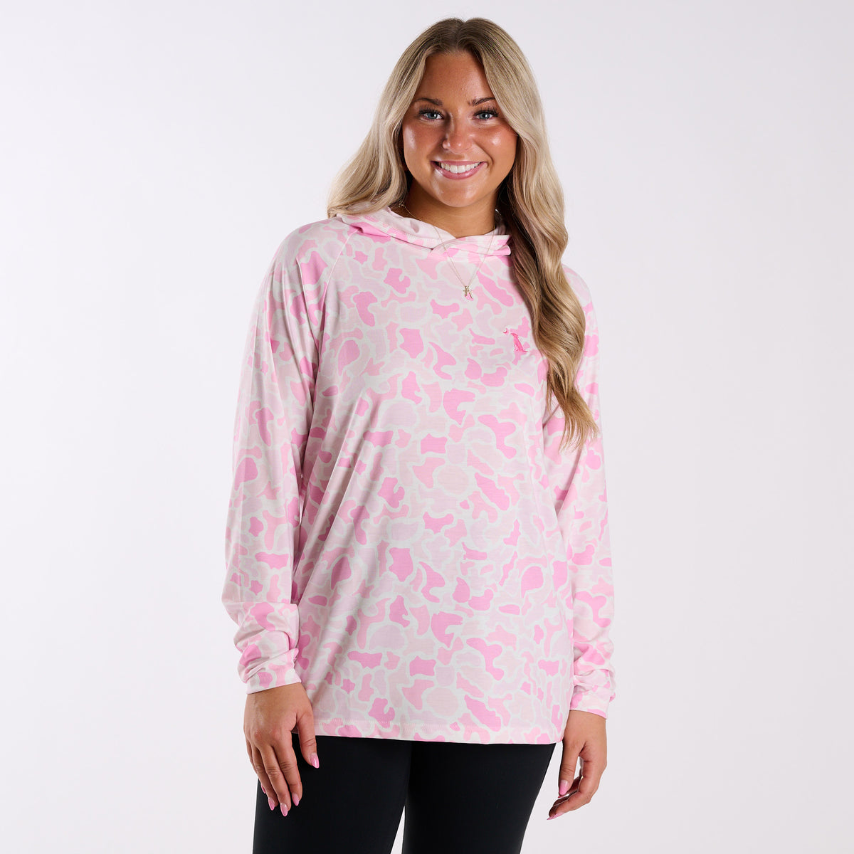 Woman wearing a pink and gray camouflage hoodie on a white background