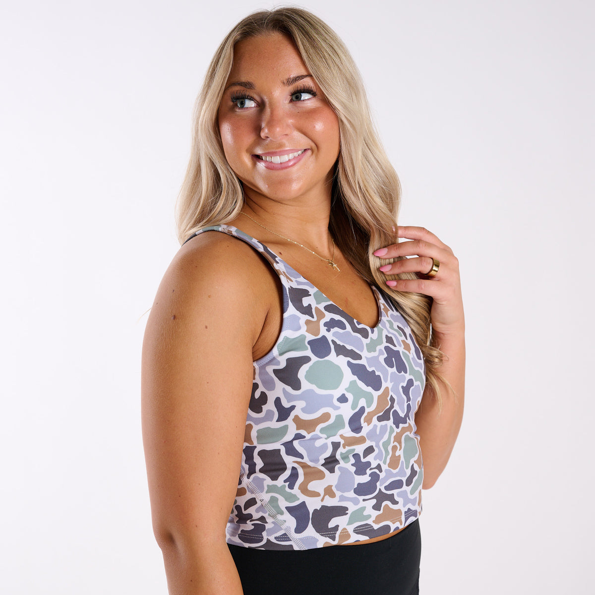 Woman wearing a patterned tank top against a white background