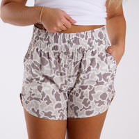 Person wearing camouflage shorts on a white background