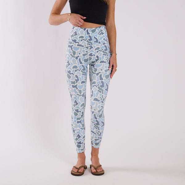 Front view of high-waisted blue camo leggings paired with black cropped tank and flip flops against white background.