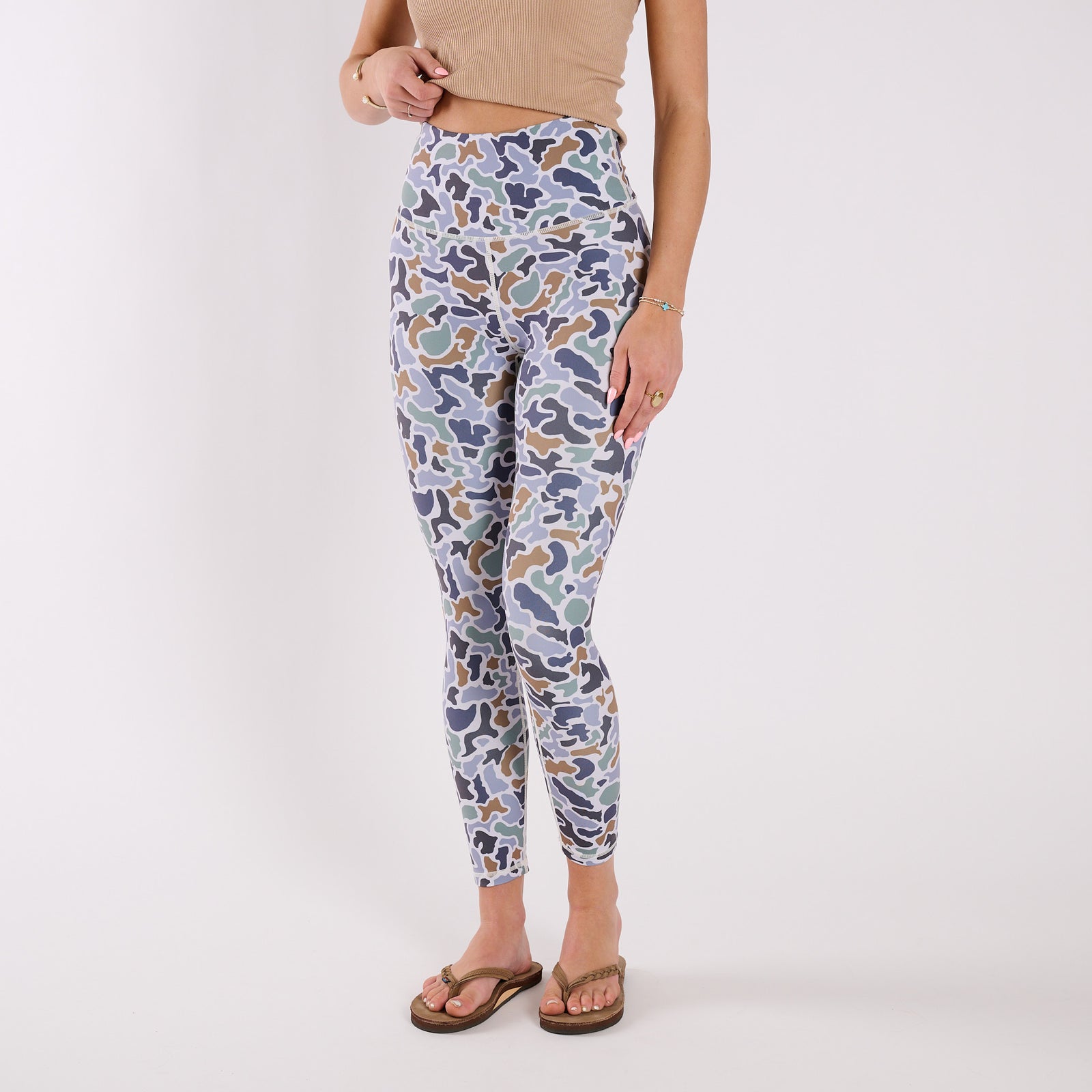 Angled front view of camo leggings showing full-length fit, side pocket seams, and tapered ankle.