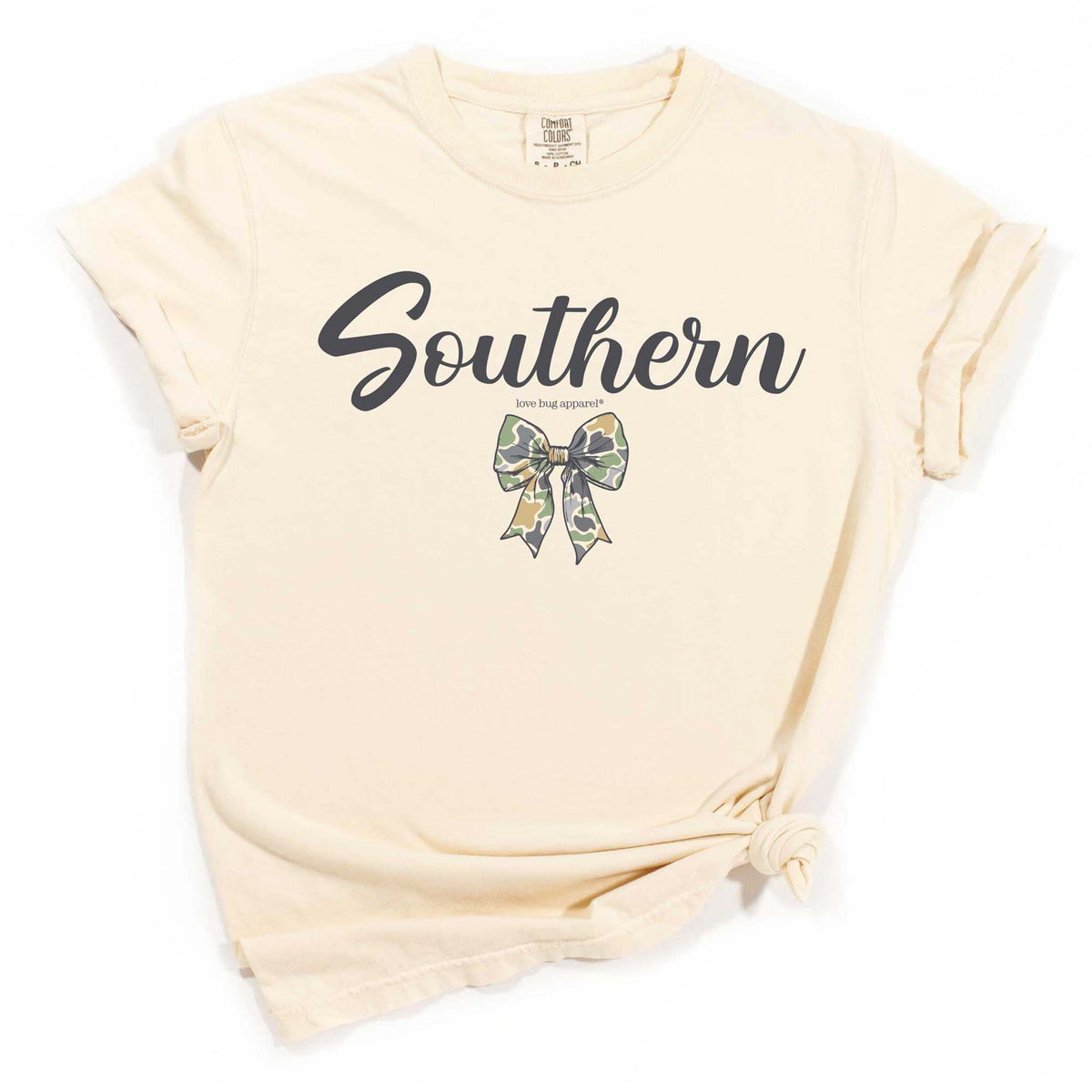 Ivory t-shirt with “Southern” script and camo bow graphic, styled with rolled sleeves and front knot.