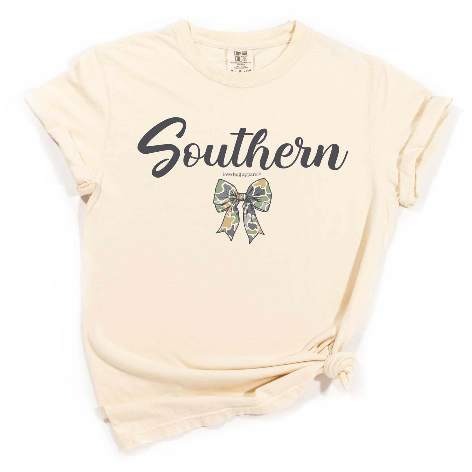 Ivory t-shirt with “Southern” script and camo bow graphic, styled with rolled sleeves and front knot.