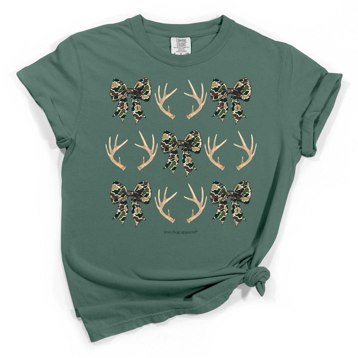 Light green t-shirt with camo bows and antler pattern arranged in a grid, styled with rolled sleeves and front knot.