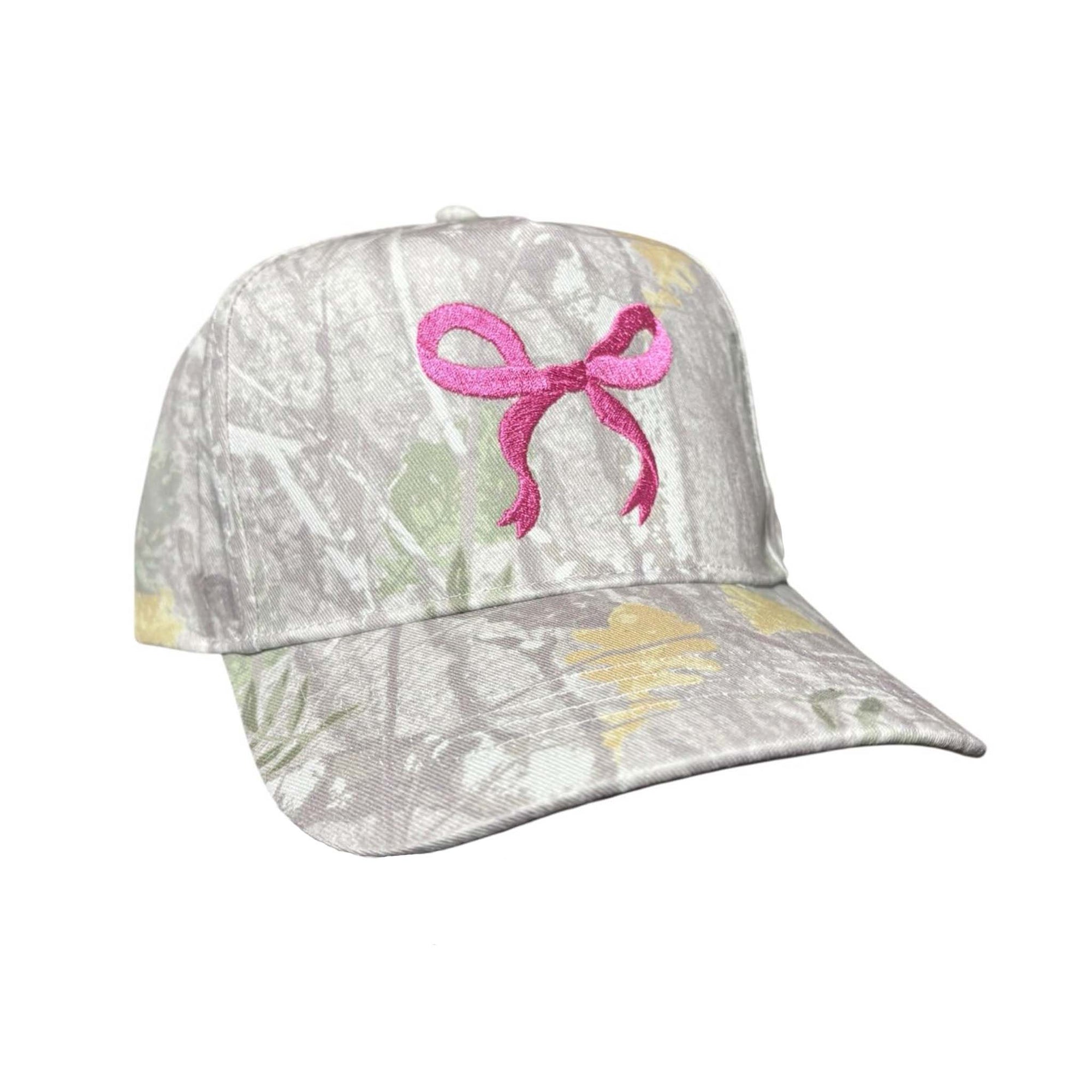 Beige camo baseball hat with embroidered pink bow on the front.