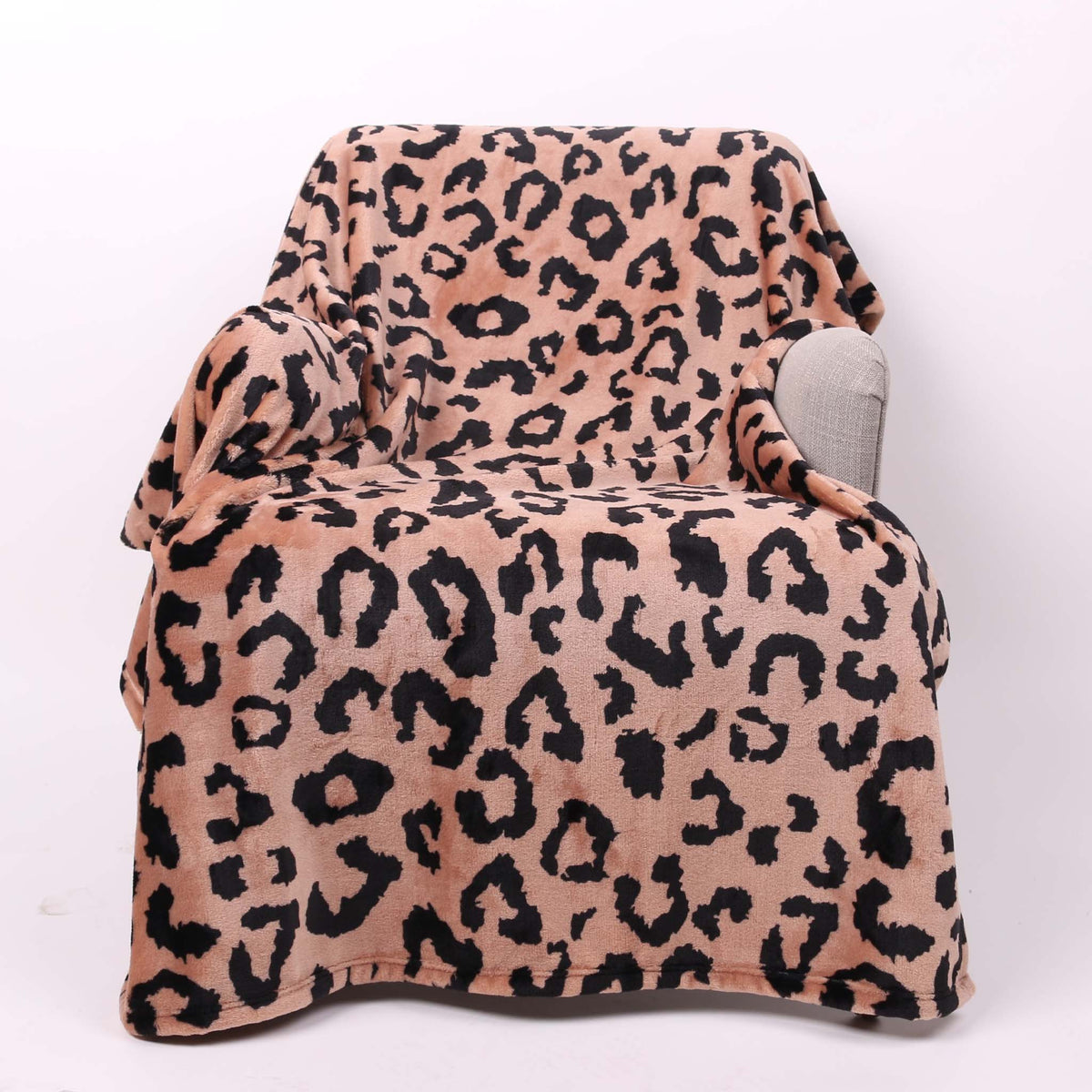 Leopard print blanket draped over a chair on a white background