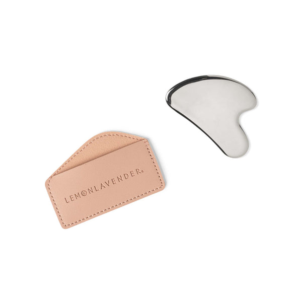 Gua Sha tool with a pink leather case on a white background