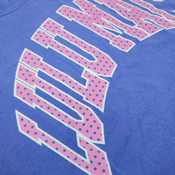 Close-up detail of pink polka dot “LULU MAC” graphic printed on flo blue Lulu Mac short sleeve t-shirt fabric.