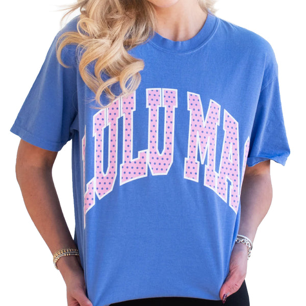 Model wearing Lulu Mac flo blue short sleeve t-shirt with large pink polka dot “LULU MAC” graphic across the chest.