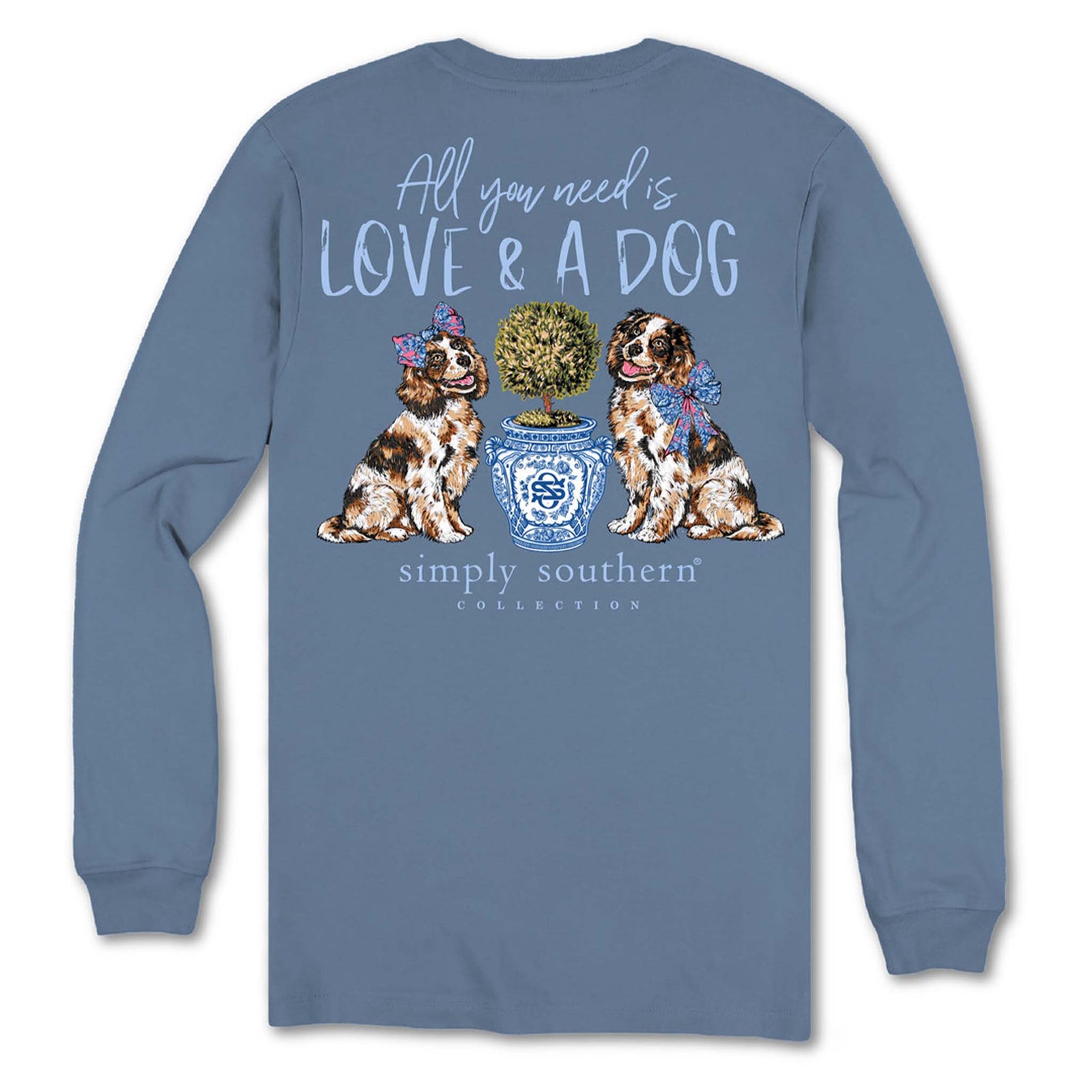 Back view of Simply Southern long sleeve shirt in slate blue with two dogs sitting beside a blue patterned planter and text that reads “All You Need Is Love & A Dog.”
