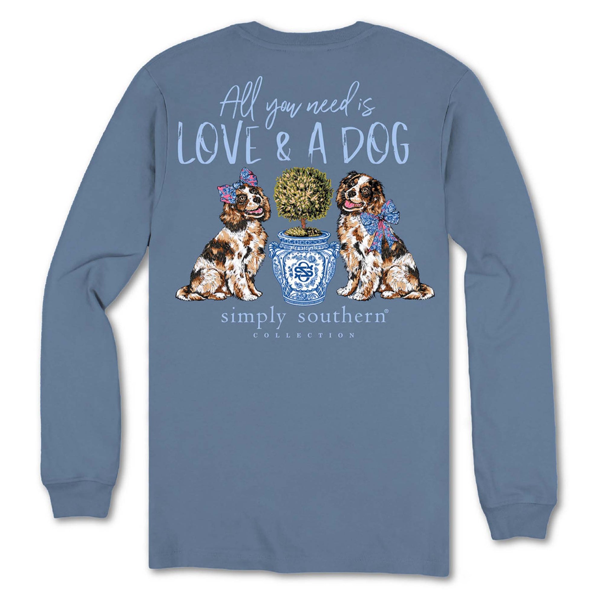 Back view of Simply Southern long sleeve shirt in slate blue with two dogs sitting beside a blue patterned planter and text that reads “All You Need Is Love & A Dog.”