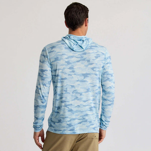 Back view of a man wearing the sea smoke blue camo hooded performance shirt.