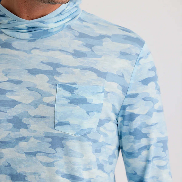 Close-up of a men’s hooded performance shirt in sea smoke blue camo with a chest pocket and lightweight fabric.