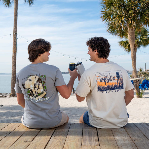  two guys sitting on a deck cheersing their drinks