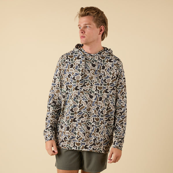 Man wearing a patterned hoodie on a beige background