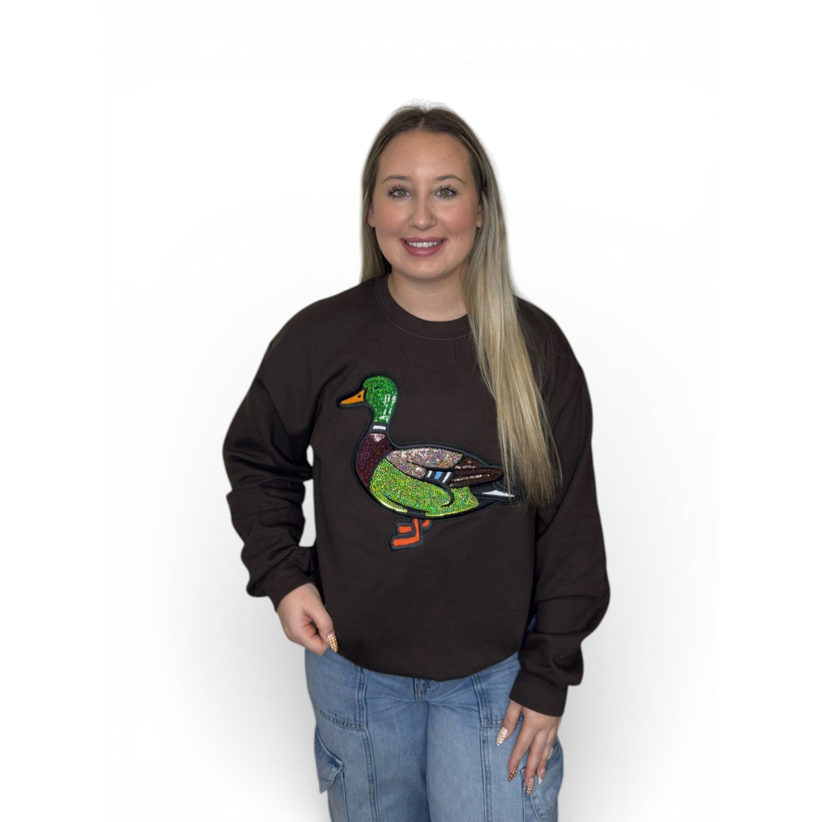 Woman wearing chocolate brown crewneck sweatshirt with large mallard duck on the front.