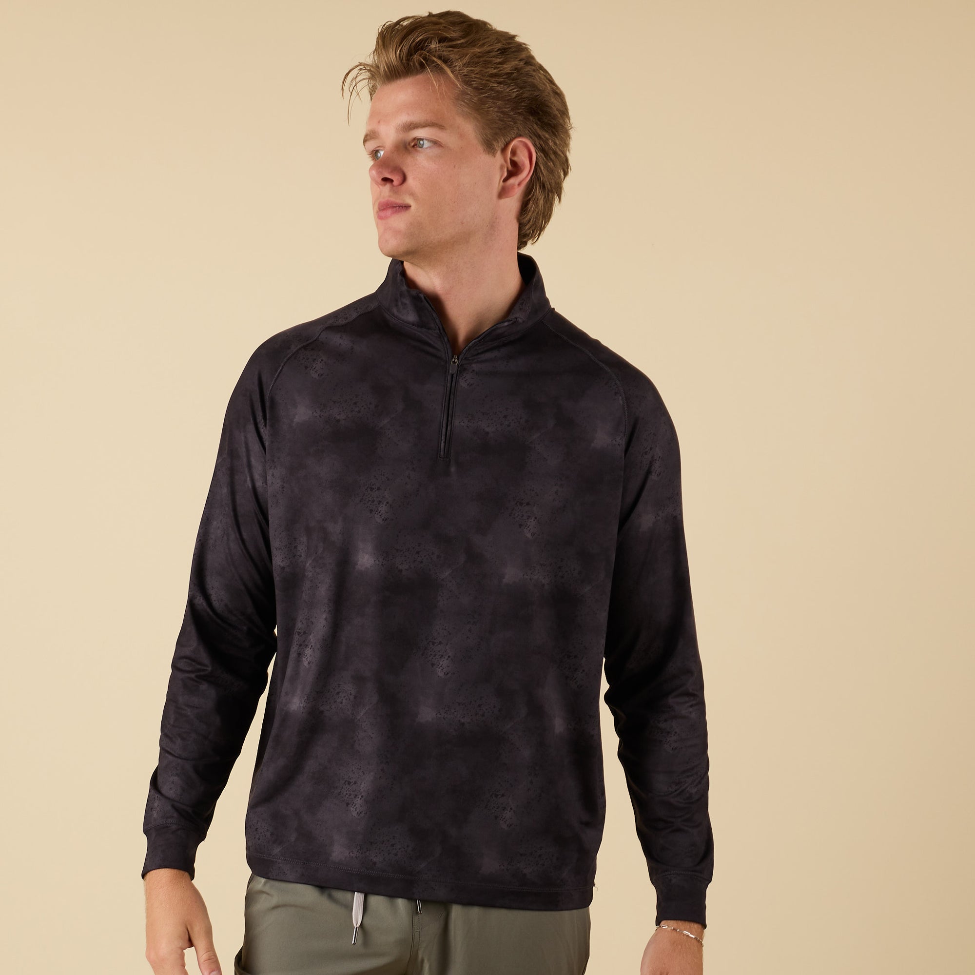 Front view of men’s black camo performance quarter-zip worn by model.
